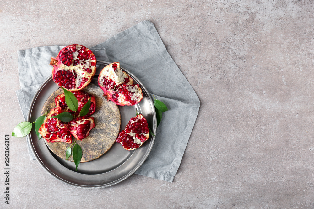 Plate with tasty pomegranates on table