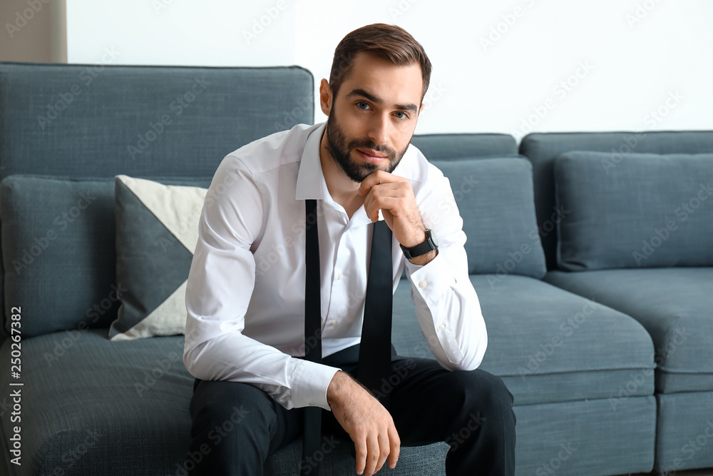 Handsome fashionable businessman sitting on sofa