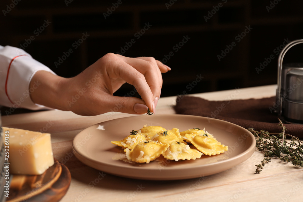 厨师用香草在盘子里装饰美味的意大利饺子