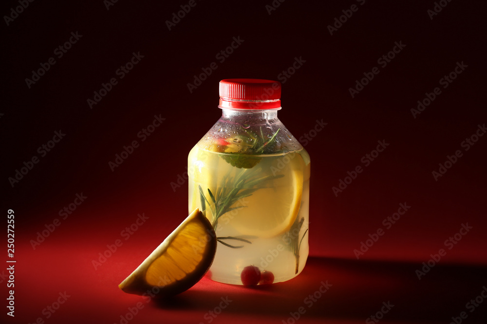 Bottle of fresh lemonade on color background