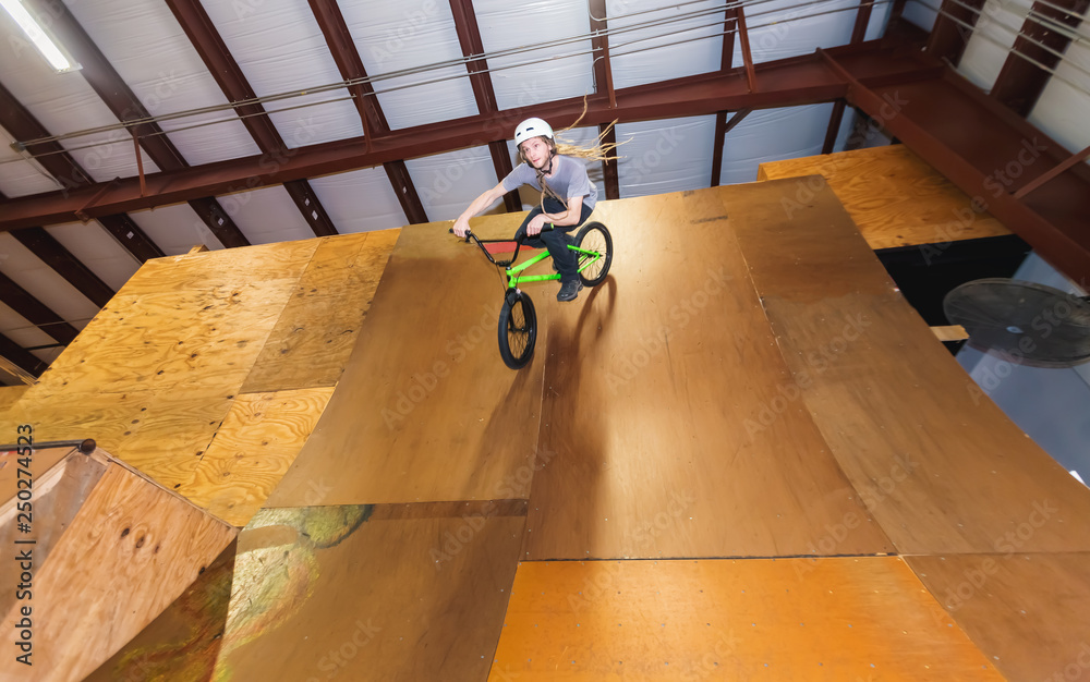 Man jumping and riding on a BMX bicycle at an extreme sports park