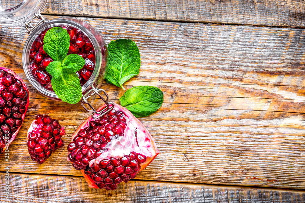 sliced pomegranate on wooden background top view