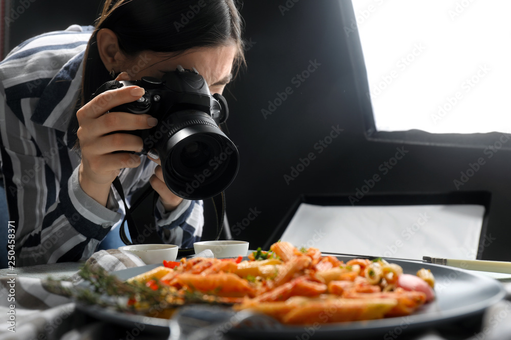 年轻女子在专业照相馆拍摄美味的意大利面