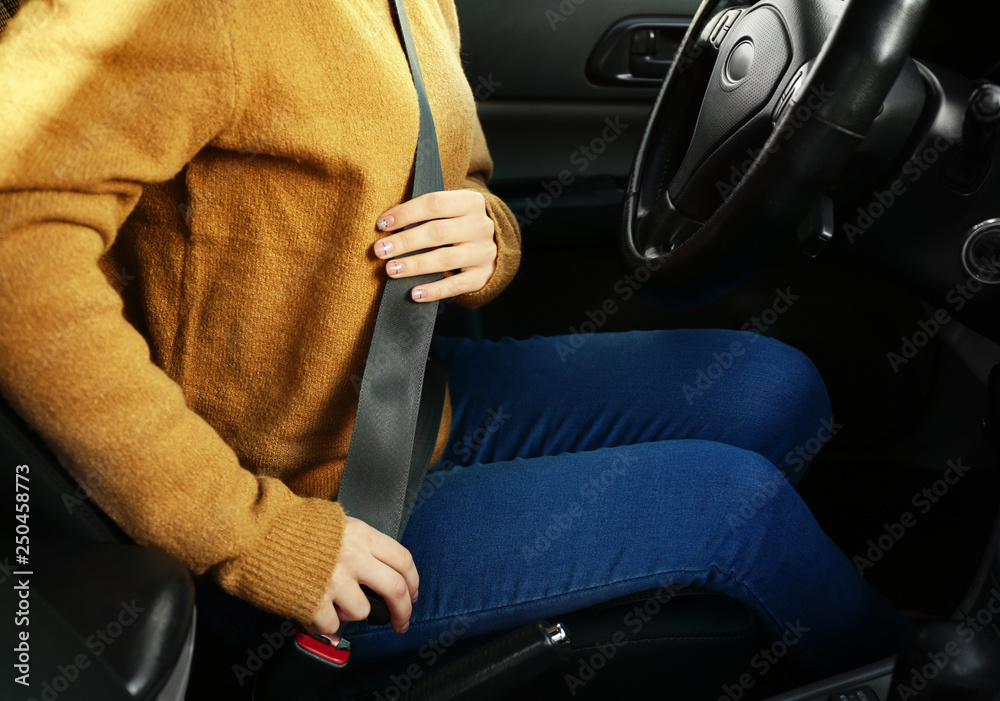 Woman buckling in car seat before passing driving license test