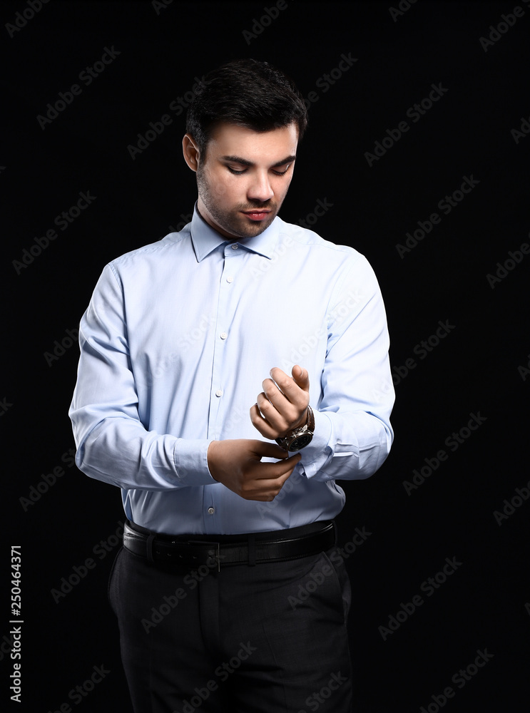 Portrait of handsome young businessman on dark background