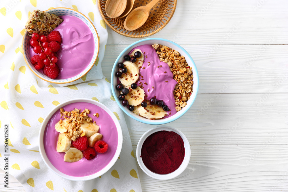 Composition with tasty acai smoothie bowls on white wooden table