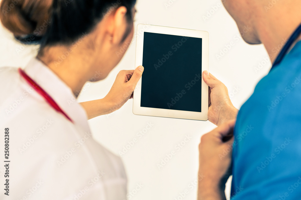 Doctors looking at data on computer at hospital.