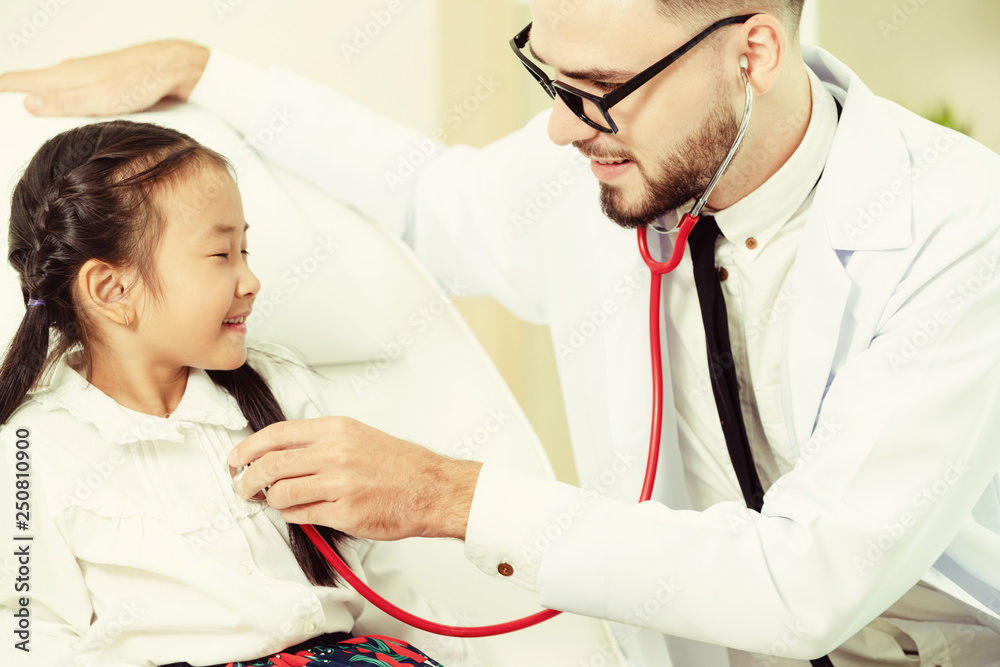 Doctor examining little happy kid in hospital.