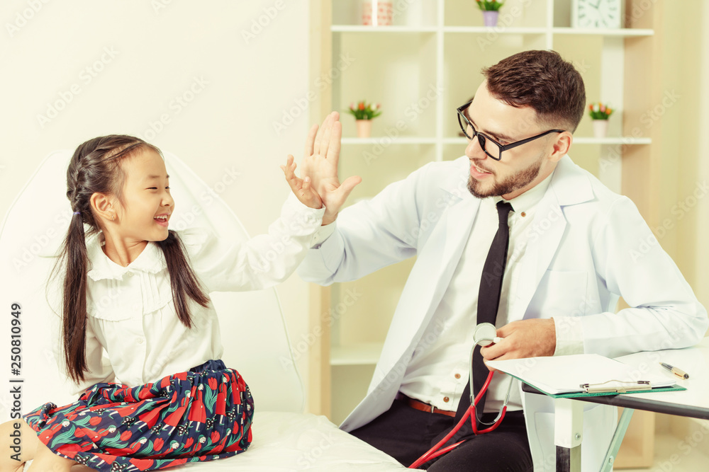 Doctor examining little happy kid in hospital.