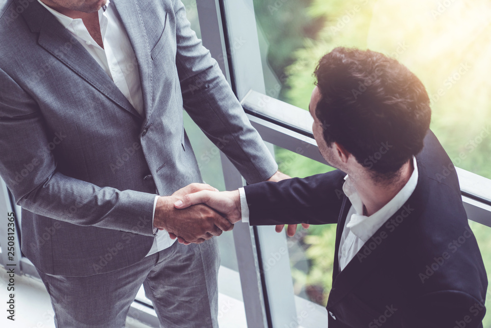 Businessmen handshake business deal in office.