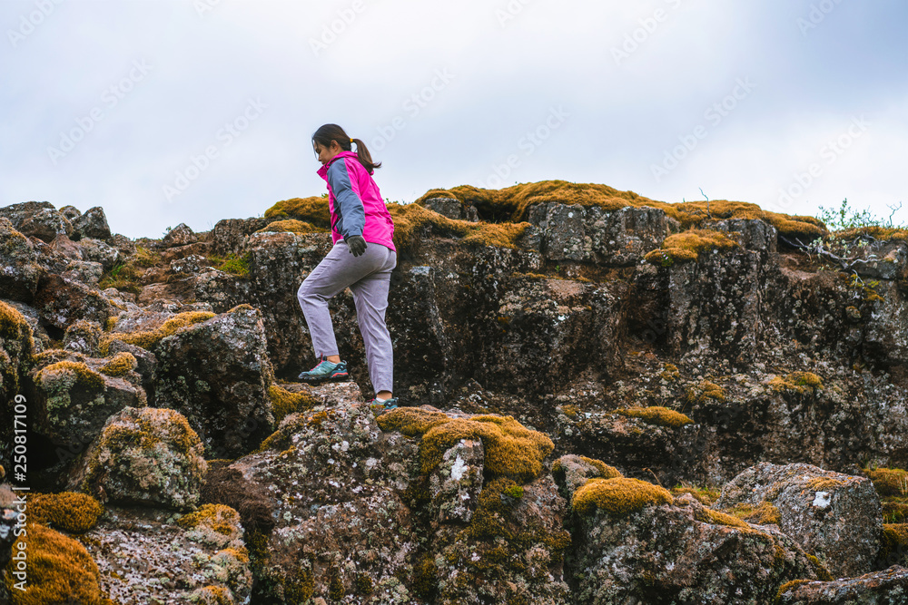 Woman traveler hiking across Iceland landscape.