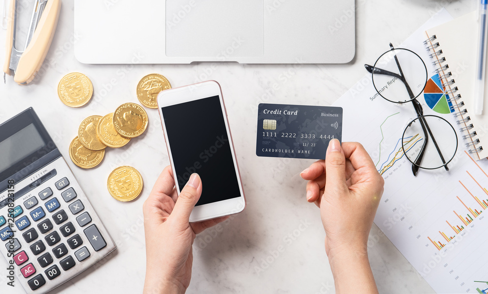 concept of a woman doing online payment with card and smartphone isolated on a modern marble office 