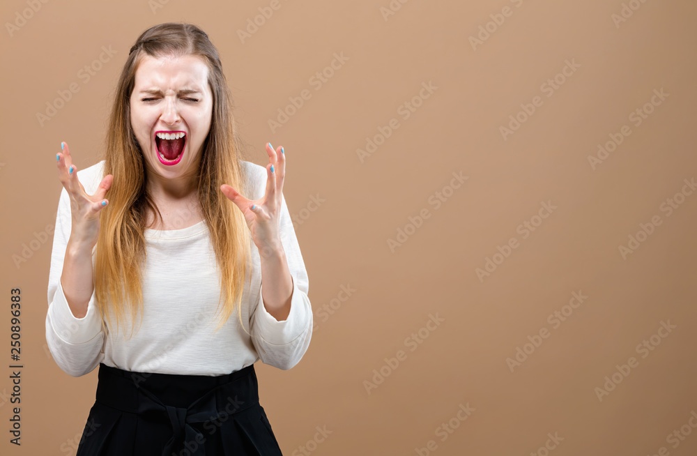 Young woman feeling stressed on a brown background