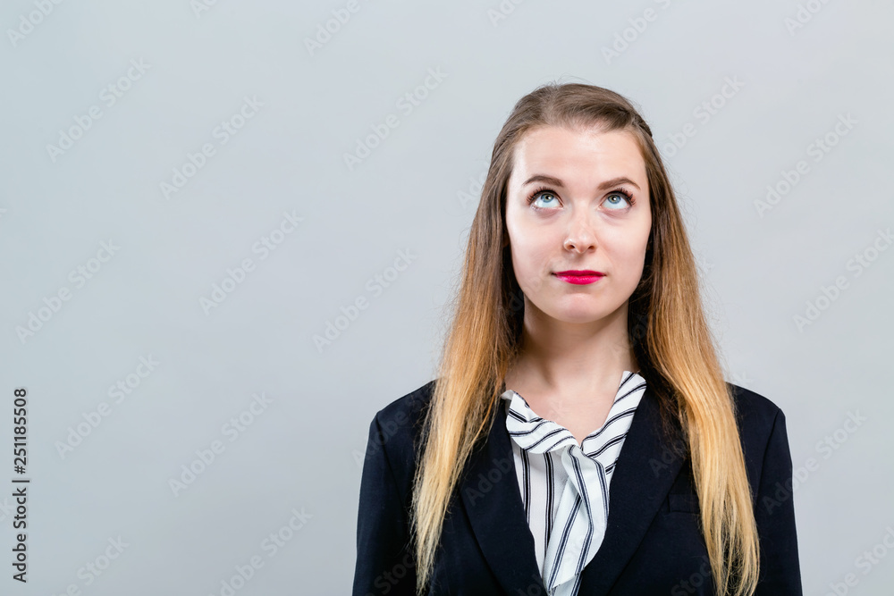 年轻女子在灰色背景上伸手向上看