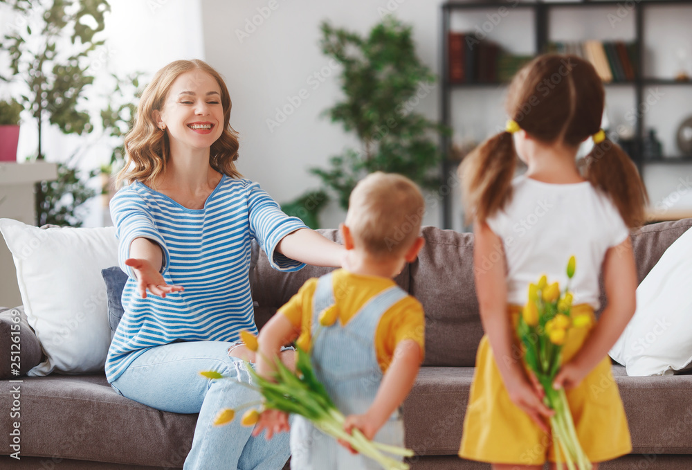 Happy mothers day! Children congratulates moms and gives her a gift and flowers .