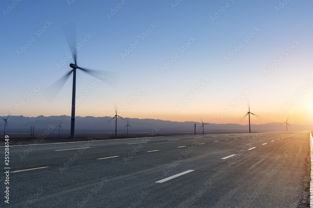 road and wind farm at dusk