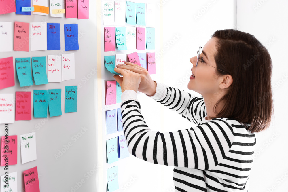 Young woman near scrum task board in office