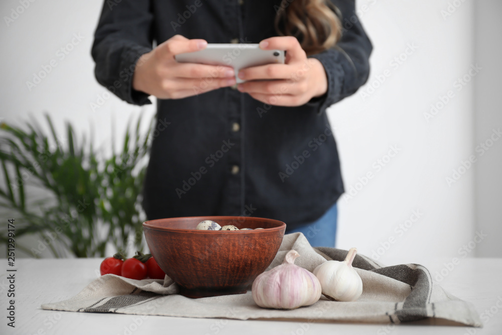 女美食摄影师拿着手机在家拍美食