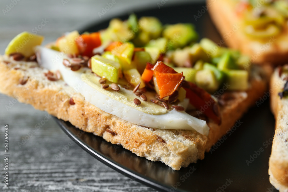 Tasty sandwich with avocado on plate, closeup