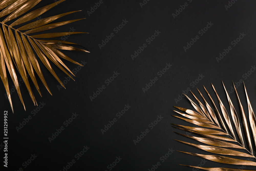 Painted golden tropical leaves on dark background