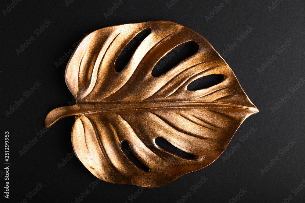 Golden tropical leaf on dark background