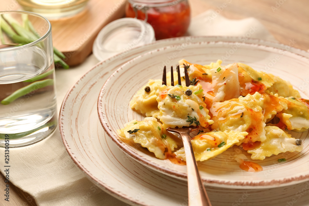 Plate with tasty ravioli on table, closeup