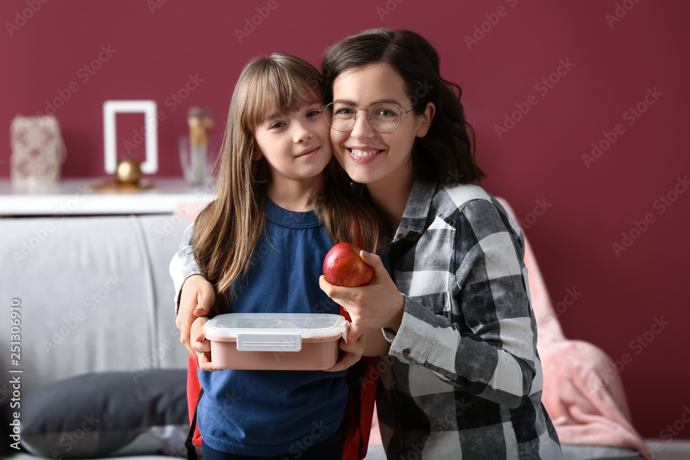 家里有妈妈和饭盒的可爱女孩的肖像