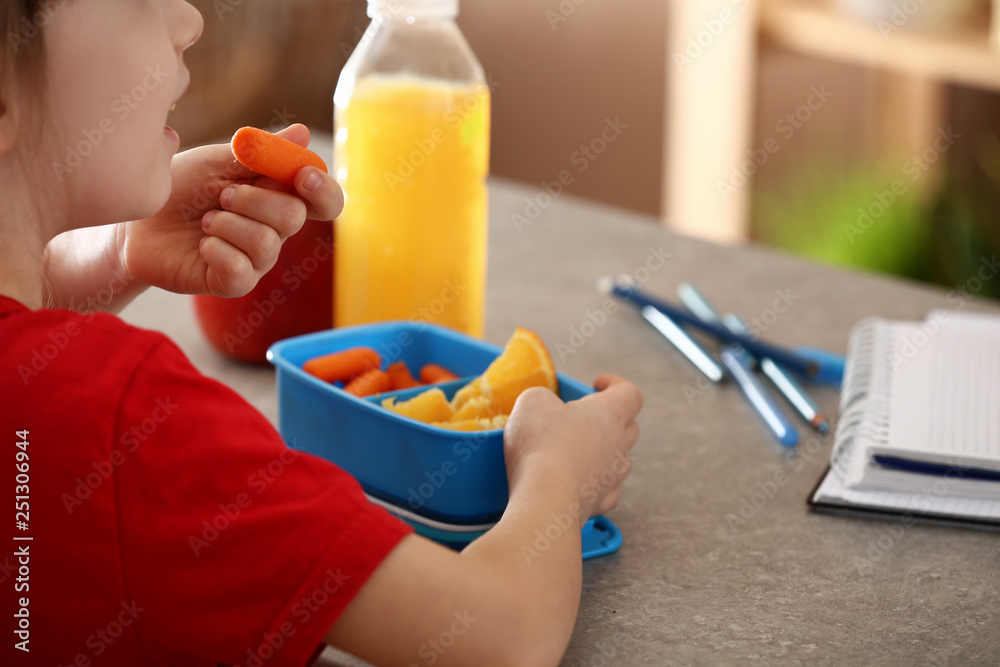 Little girl having school lunch in classroom