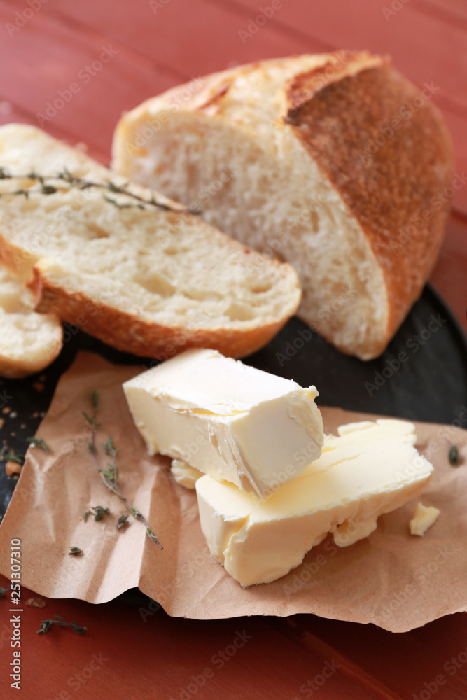 Plate with tasty butter and bread on table