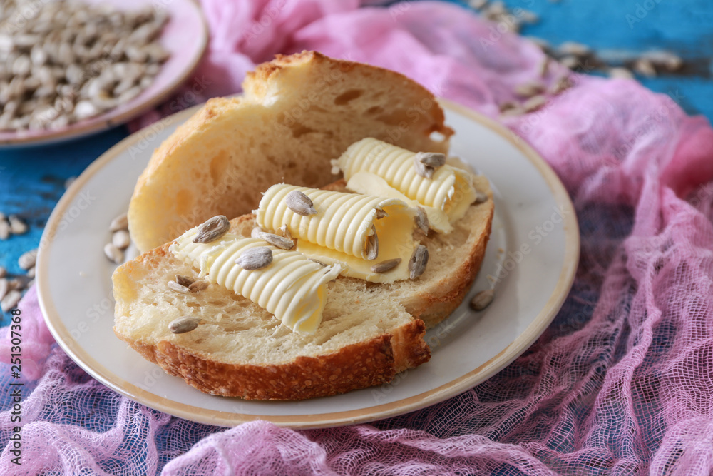 Plate with tasty butter and bread on table