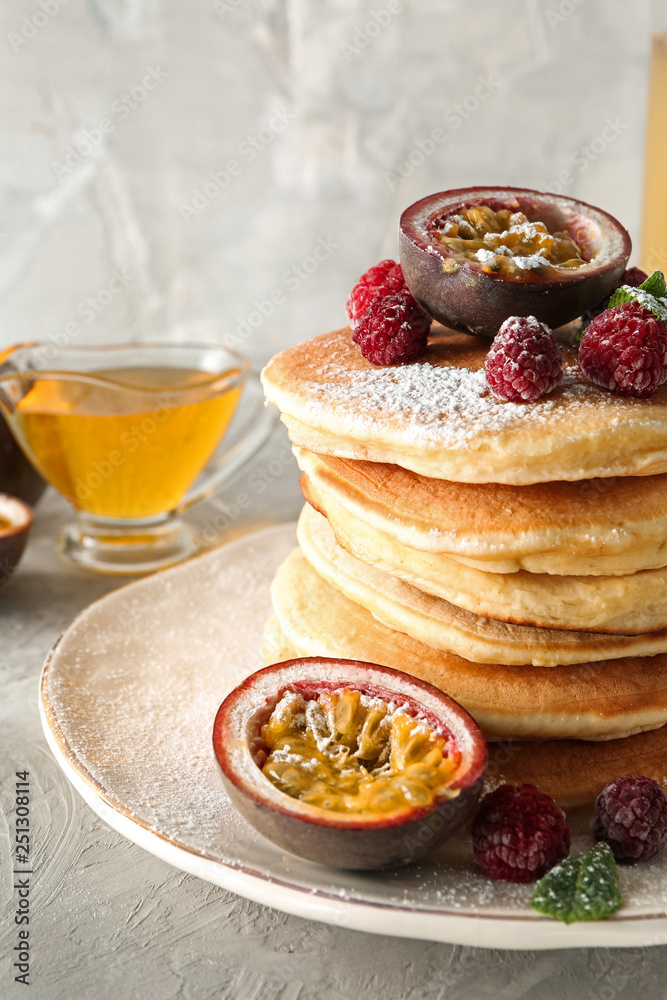 Tasty pancakes with passion fruit and berries on plate