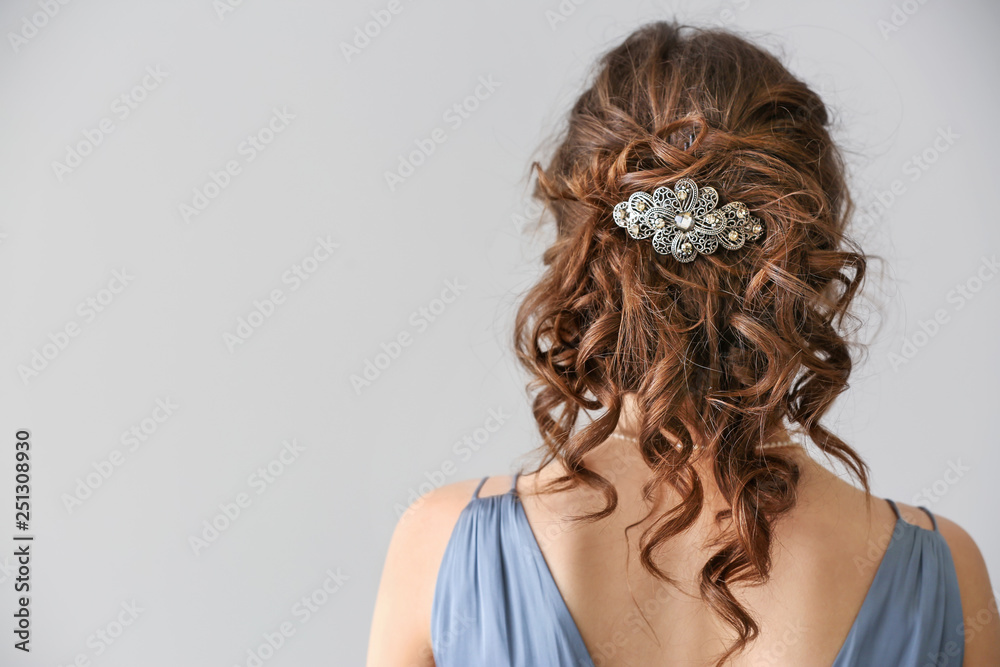 Young woman with beautiful jewelry on light background