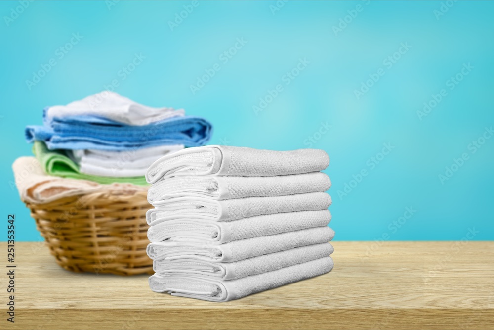 Laundry Basket with colorful towels on background