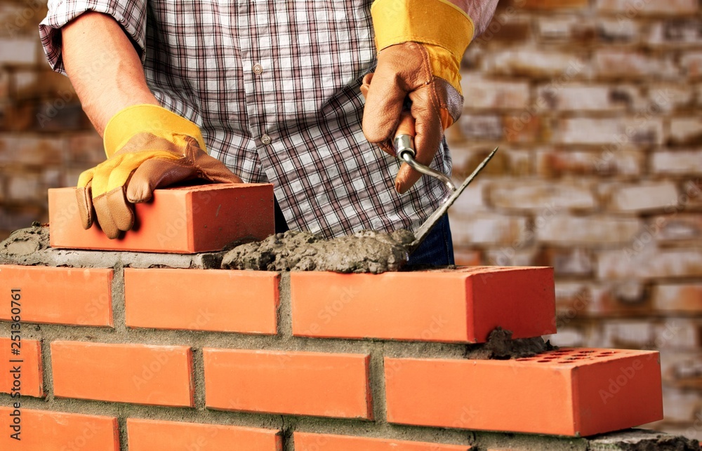 Worker builds a brick wall