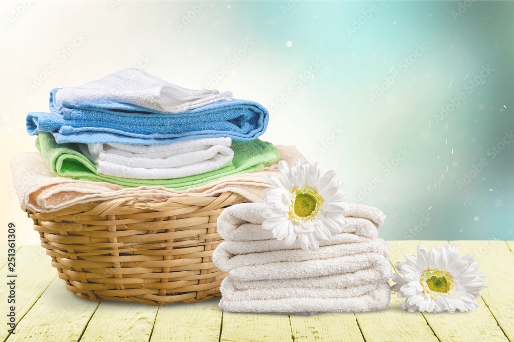 Laundry Basket with colorful towels on background