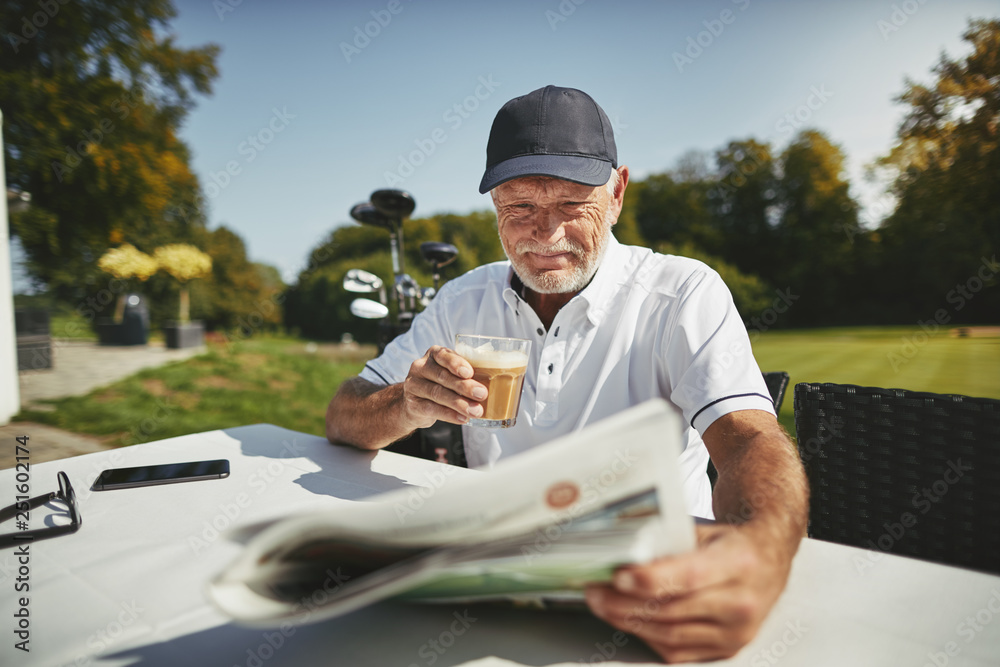 Smiling senior man drinking coffee after a round of golf