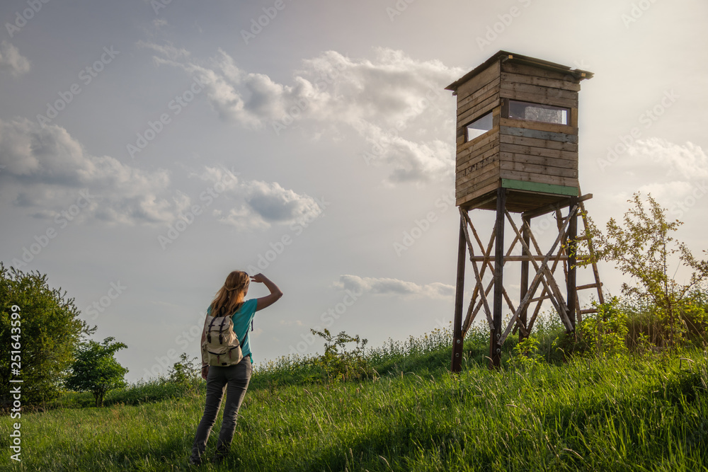 Woman tourist looking to lookout tower at countryside