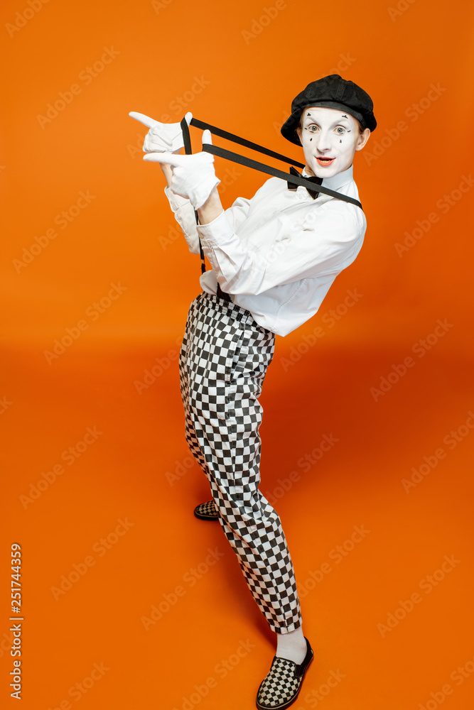 Full length portrait of an actor as a pantomime with white facial makeup showing expressive emotions