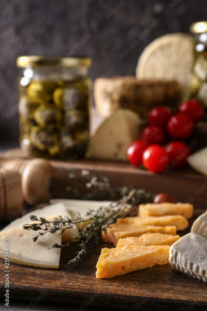 Assortment of tasty cheese on wooden board