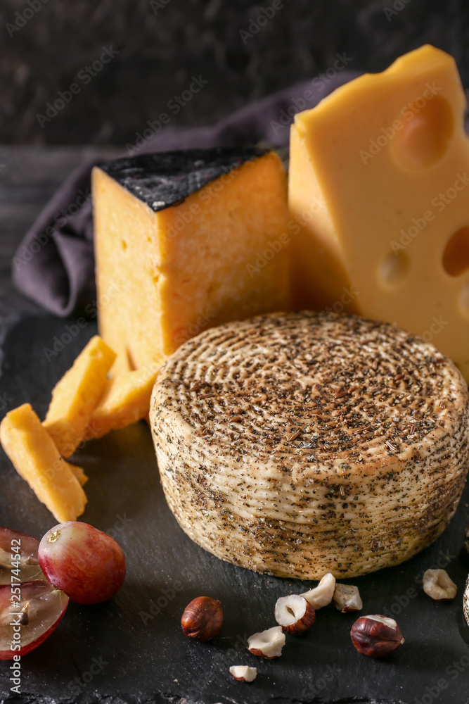 Assortment of tasty cheese on slate plate