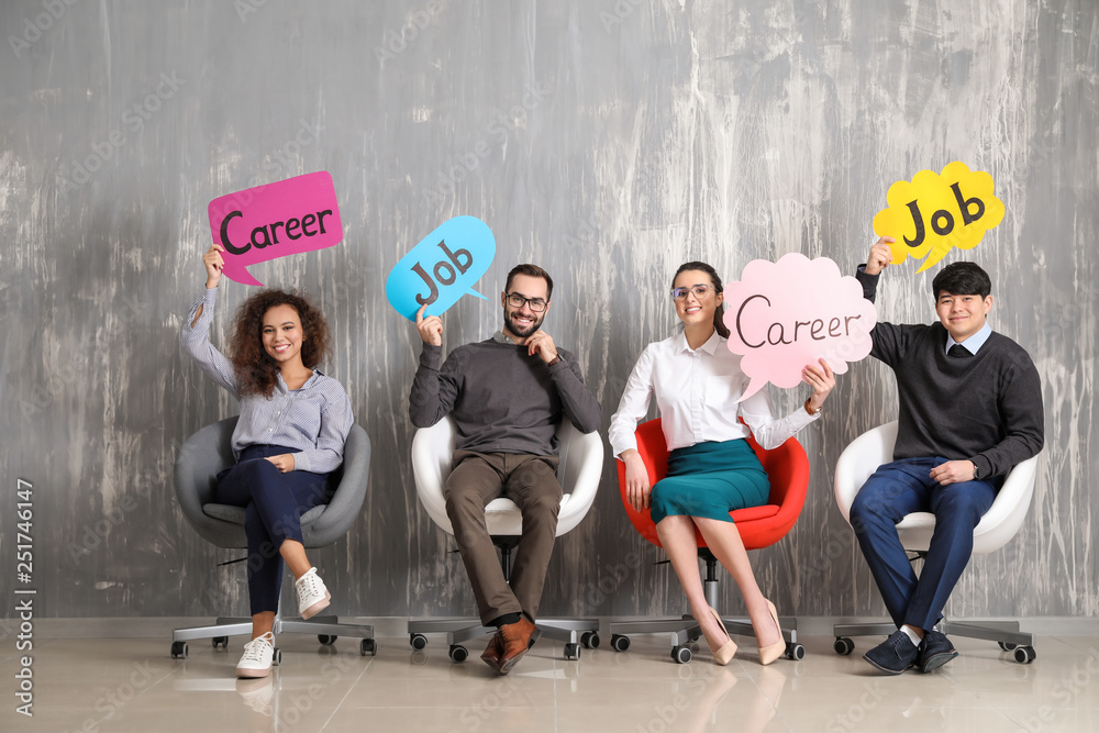 Young people holding speech bubbles with words JOB and CAREER indoors