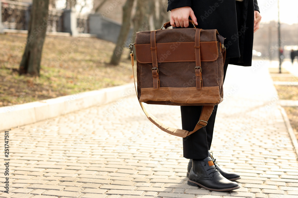 Businessman with stylish briefcase on city street