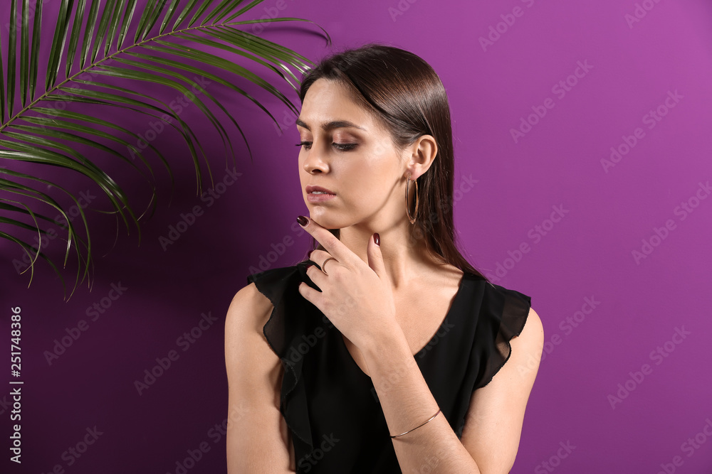 Young woman with beautiful jewelry on color background