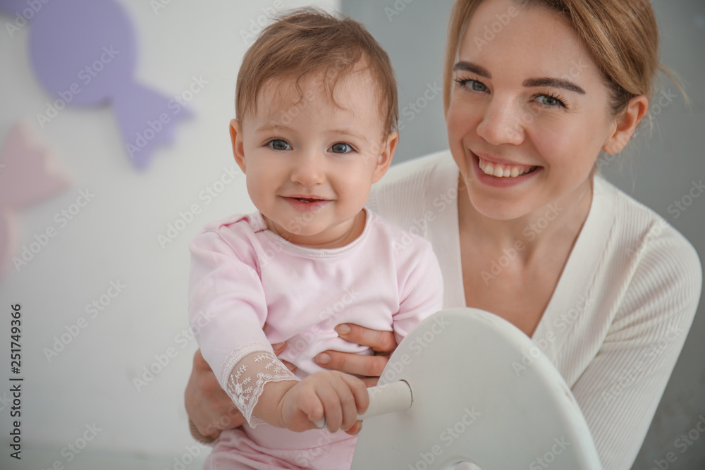 Mother with cute baby girl at home