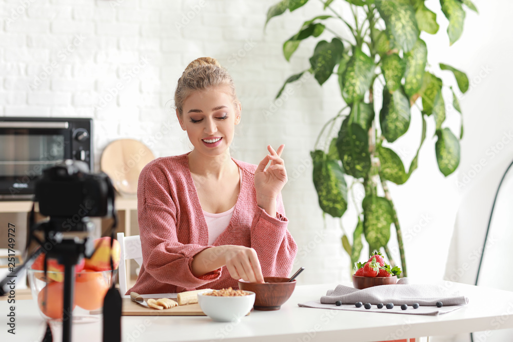 Young female food blogger recording video indoors