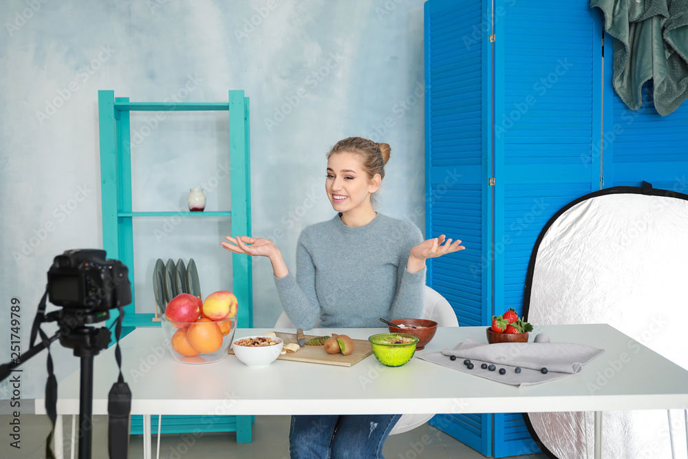 Young female food blogger recording video indoors