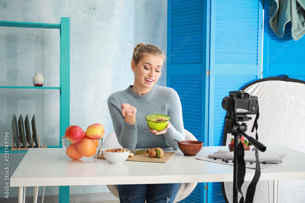 Young female food blogger recording video indoors