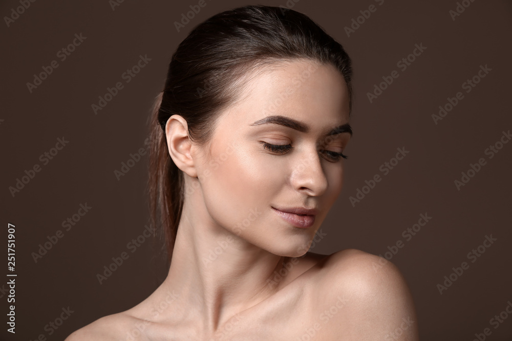 Young woman with beautiful eyebrows on color background