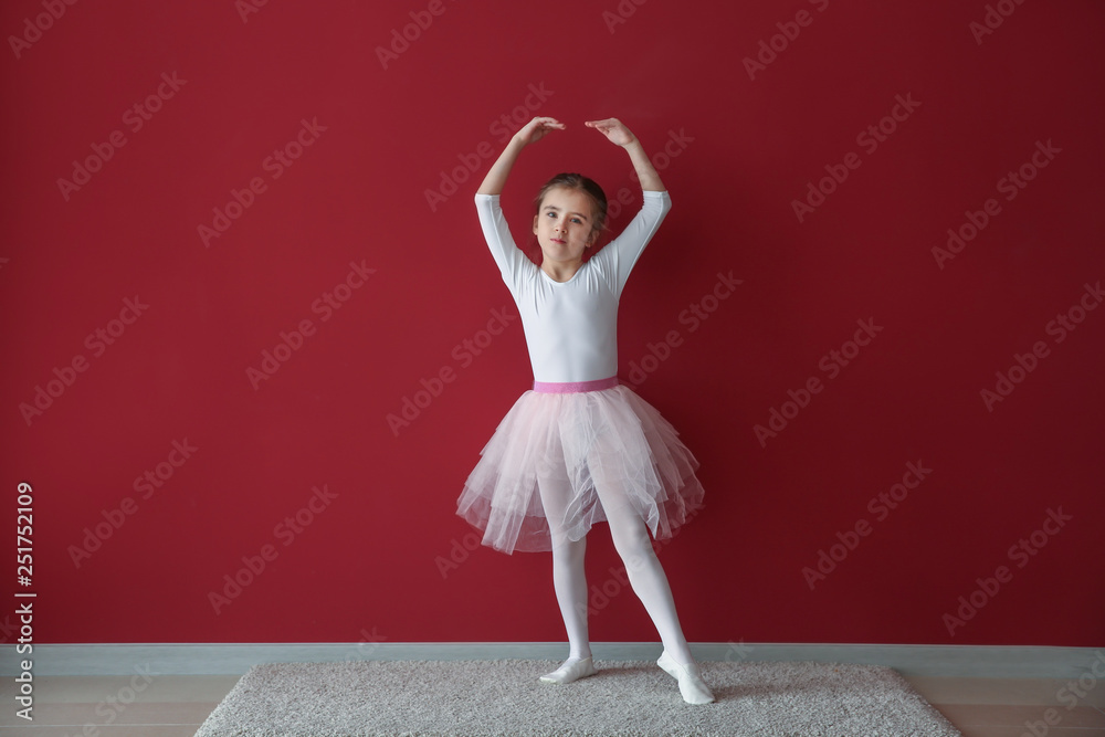 Cute little ballerina near color wall