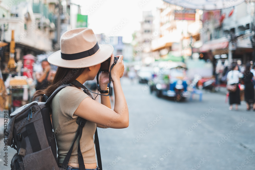 Asian woman tourist backpacker travel and taking photo in Khao San road, Bangkok, Thailand